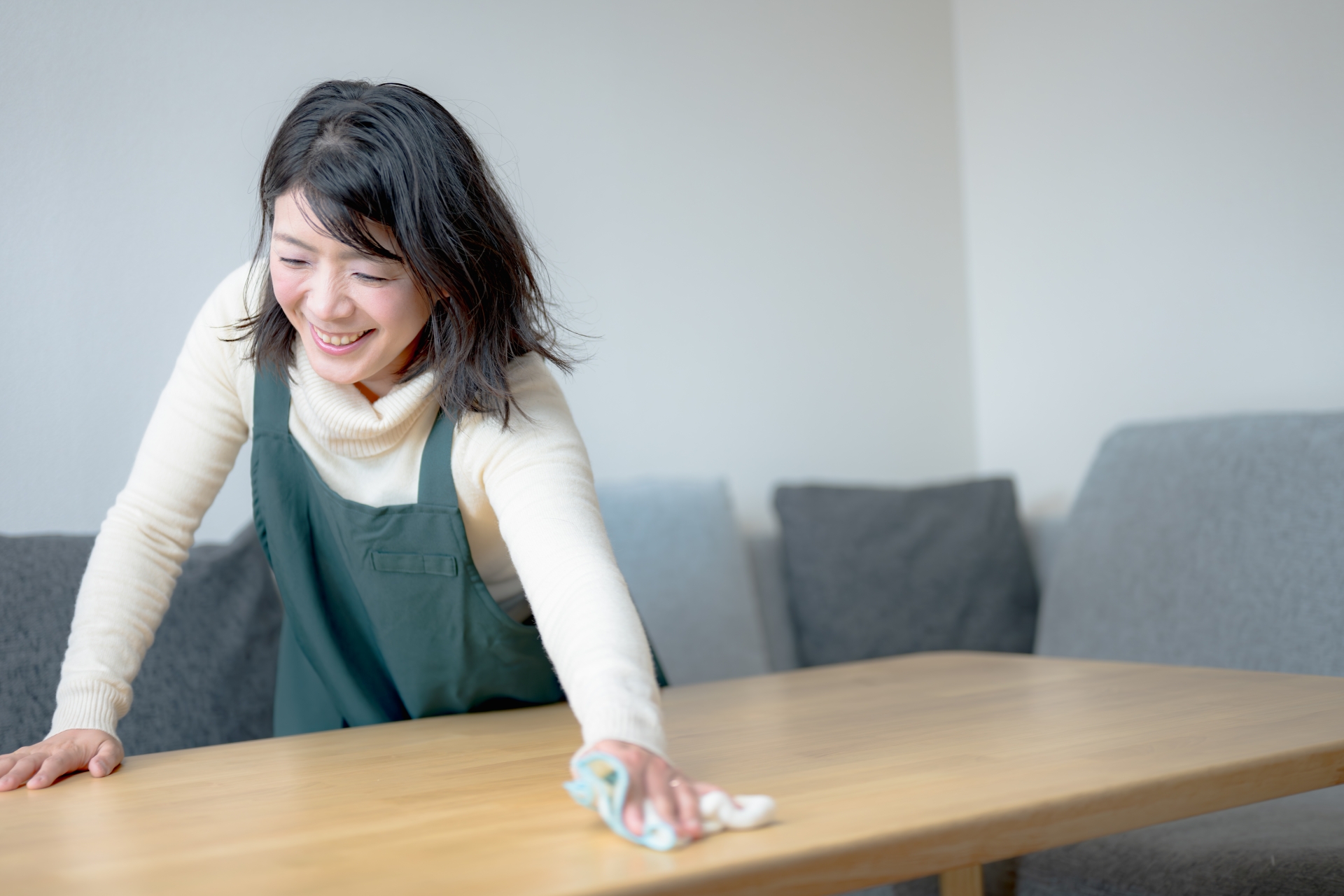 笑顔でテーブルを拭いている女性