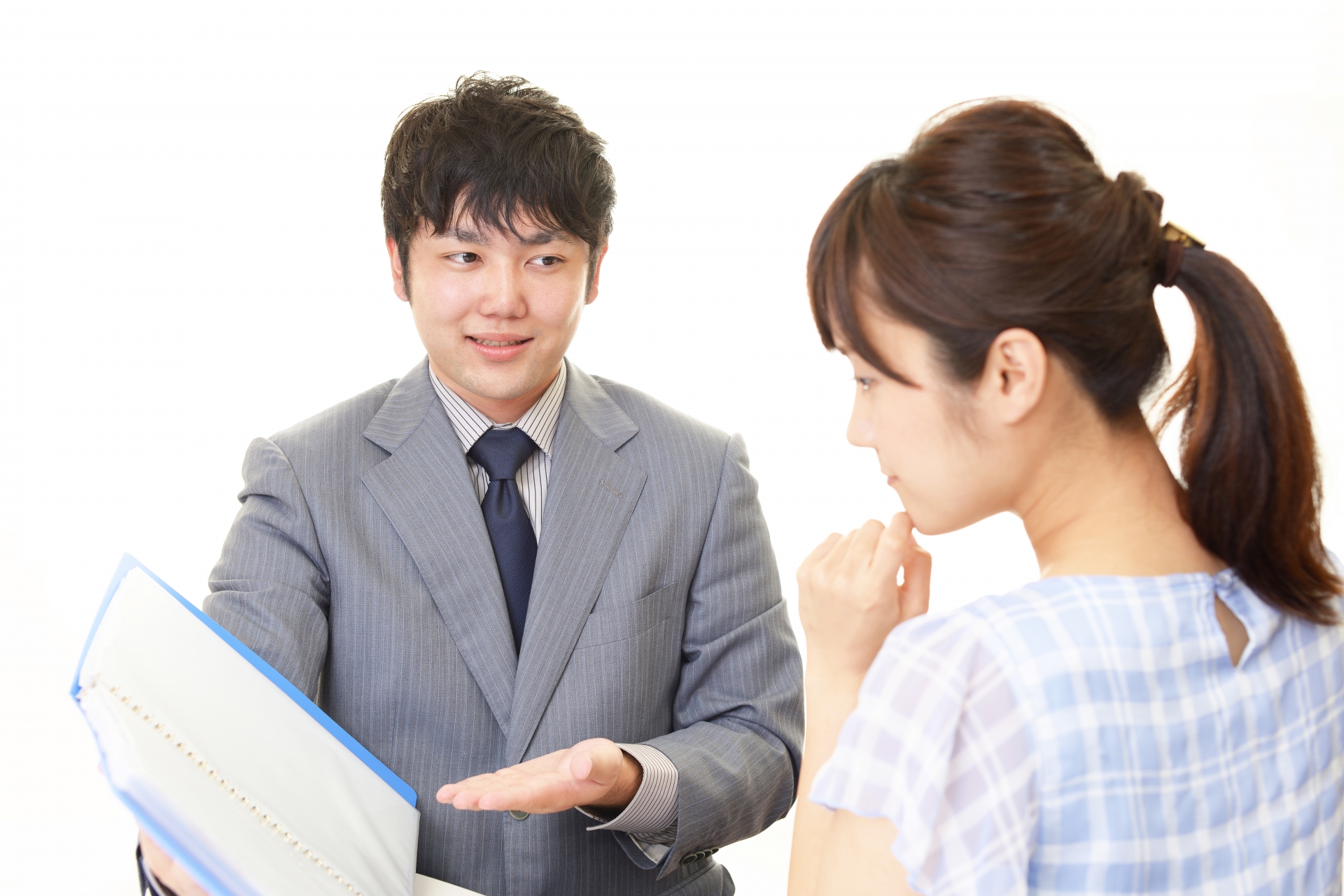 押し売りセールスマン男性が女性に話しかけている